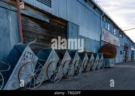 Alte Wagen bins aufgereiht entlang der Seite des Monterey Fish Company Gebäude auf einem Pier in Monterey Bay, Kalifornien. Stockfoto