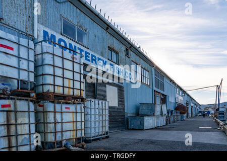 Alten rostigen Container auf der Seite des Monterey Fish Company Gebäude an der Pier in Monterey Bay, Kalifornien gestapelt. Stockfoto