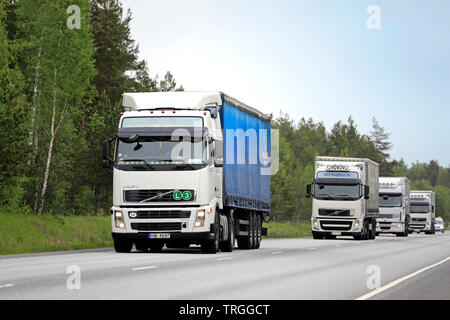 Raasepori, Finnland. 24. Mai 2019. Flotte von weißen Lkw, Volvo FH und Renault Premium, in Highway Traffic an einem bewölkten Tag der Frühling in Finnland Stockfoto