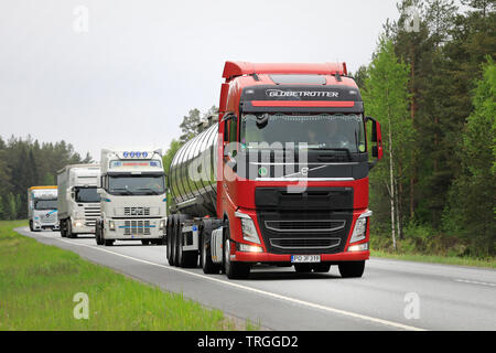 Raasepori, Finnland. 24. Mai 2019. Flotte von vier schweren Lkw durch einen roten Volvo FH 500 semi Tanker auf der Autobahn an einem bewölkten Tag im Sommer in Finnland geführt. Stockfoto