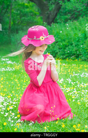 Schöne Mädchen im Park, Kommissionierung und Blumen aus der Daisy-Feld. Stockfoto