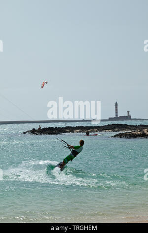 Kitesurf en Punta Willits. Al fondo El Faro de Tostón. Parque Natural de Corralejo. Isla Fuerteventura. Provinz Las Palmas. Islas Canarias. España Stockfoto