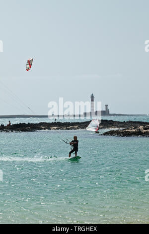 Kitesurf en Punta Willits. Al fondo El Faro de Tostón. Parque Natural de Corralejo. Isla Fuerteventura. Provinz Las Palmas. Islas Canarias. España Stockfoto