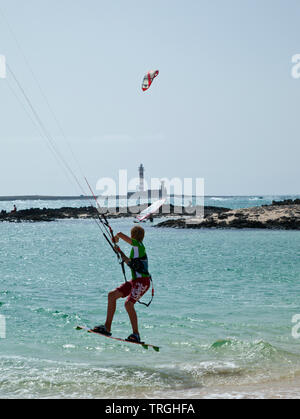 Kitesurf en Punta Willits. Al fondo El Faro de Tostón. Parque Natural de Corralejo. Isla Fuerteventura. Provinz Las Palmas. Islas Canarias. España Stockfoto