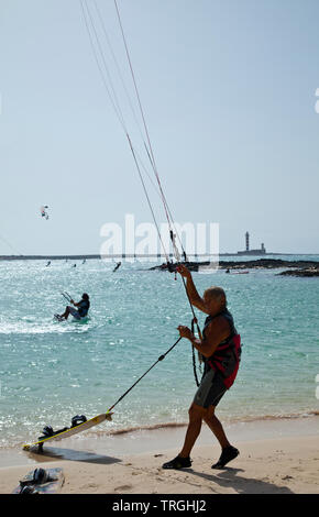 Kitesurf en Punta Willits. Al fondo El Faro de Tostón. Parque Natural de Corralejo. Isla Fuerteventura. Provinz Las Palmas. Islas Canarias. España Stockfoto