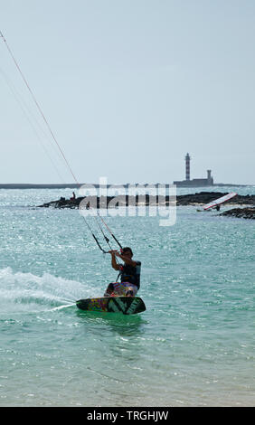 Kitesurf en Punta Willits. Al fondo El Faro de Tostón. Parque Natural de Corralejo. Isla Fuerteventura. Provinz Las Palmas. Islas Canarias. España Stockfoto