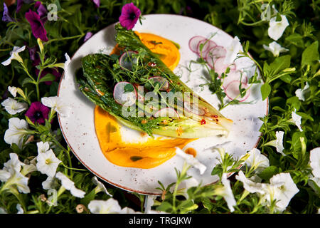 Sommer Salat auf einen Teller unter den Blumen Stockfoto