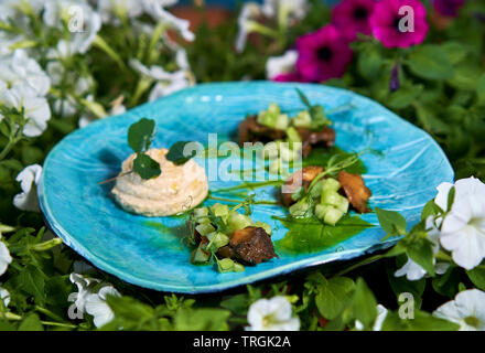 Sommer Salat auf einen Teller unter den Blumen Stockfoto