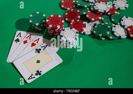 Vier Asse und Poker chips, auf grüner Fläche, mit Nachmittag Sonnenlicht Stockfoto