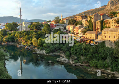 Goldene Stunde über den Fluss Neretva Banken der Stadt Mostar in Bosnien und Herzegowina von der berühmten Brücke aus gesehen. Stockfoto