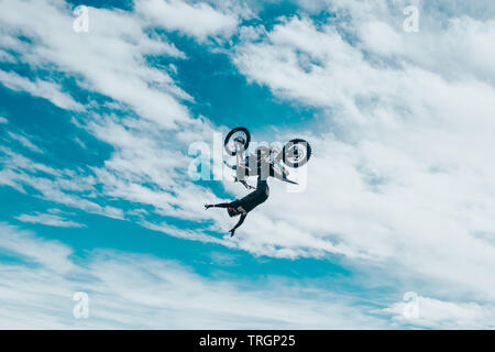 Freestyle Motorcross Sportler springen Dirtbike in den Wolken Stockfoto