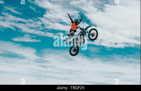 Freestyle Motorcross Sportler springen Dirtbike in den Wolken Stockfoto