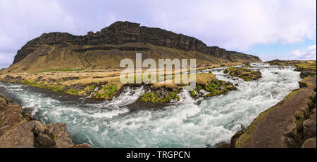 Panoramablick über Stromschnellen und kleinen Wasserfällen auf der Fossálar River im Süden Islands. Stockfoto