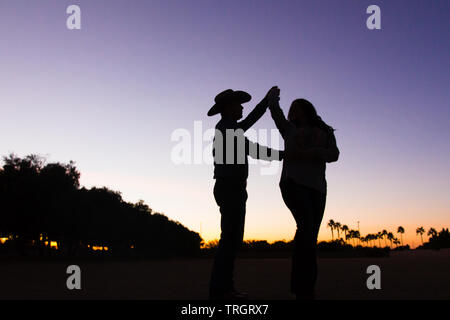 Country Familie im Sonnenuntergang tanzen und springen Stockfoto