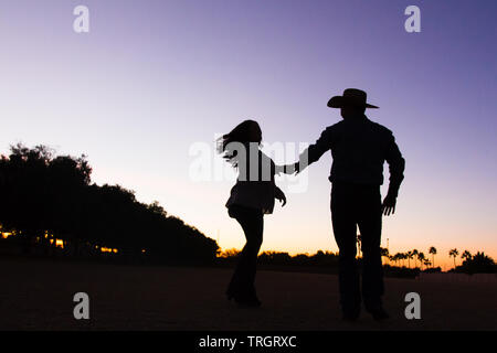 Country Familie im Sonnenuntergang tanzen und springen Stockfoto