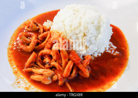 Tintenfischringe gebraten Curry mit Reis auf weiße Platte - asiatische Lebensmittel rühren Stockfoto