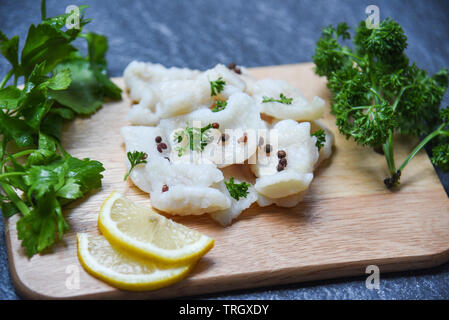 Gekochter Fisch Filet Stück mit Zitrone und Gewürzen auf Holz Schneidebrett Hintergrund/Pangasius dolly Fisch Fleisch Stockfoto