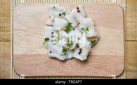 Gekochter Fisch Filet Stück mit Gewürzen auf Holz Schneidebrett Hintergrund/Pangasius dolly Fisch Fleisch Stockfoto