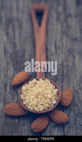 Kleine Stücke gehackten Mandeln in Holz- Schaufel mit ganzen, Stockfoto