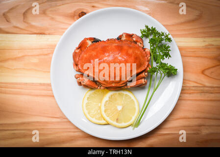 Gekochte Krabben auf weiße Platte mit Zitrone Kräuter und Gewürze/Meeresfrüchte gekochte rote Stein salat Krabben Stockfoto