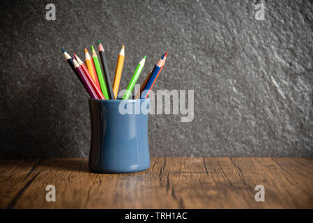 Bildung und zurück in die Schule Konzept mit Bleistifte bunt in einem Federmäppchen auf dunklem Hintergrund / Holz Kreide Stockfoto