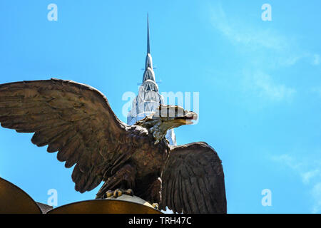 New York, USA, 21. Mai 2019. Eine große Cast-iron Eagle sitzt auf Grand Central Station vor dem Chrysler Building in New York City. Cred Stockfoto