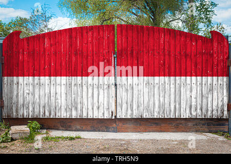 Nahaufnahme der Nationalflagge von Indonesien auf einem hölzernen Tor am Eingang des geschlossenen Gebiet an einem Sommertag. Das Konzept der Lagerung von Waren, Stockfoto