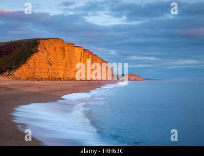 Die Wellen auf den Strand unter Osten Klippen, West Bay, Jurassic Coast, Dorset, England, Großbritannien, Stockfoto