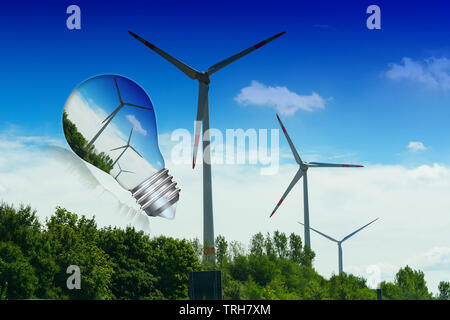 Lampe mit Windenergieanlage im Inneren. Im Hintergrund blauer Himmel und grünen Bäumen mit Turbinen. Konzeptionelle Bild Stockfoto
