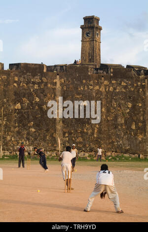 Ein laienhaftes Spiel Cricket an der Galle International Stadium in Galle, Sri Lanka gespielt. Niederländische der Stadt erbaute Festung ist im Hintergrund zu sehen. Ein Stockfoto