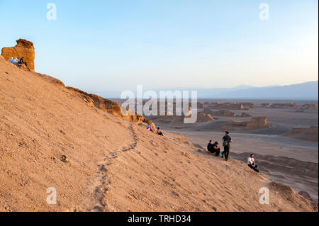 Touristen beobachten den Sonnenuntergang über den Yardags in der Lut-Wüste in Shahad, Iran. Im Iran als Kaluts bekannt, sind Yardags geologische Formationen. Stockfoto