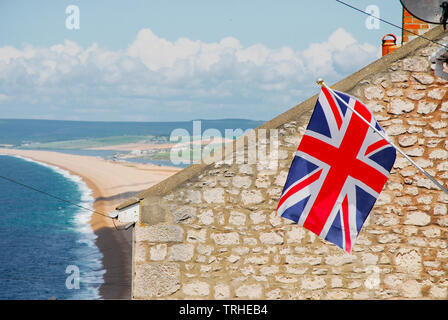 Chesil Beach, Dorset. 6. Juni 2019. Eine britische Union Flag zum Gedenken an den 75. Jahrestag des D-Day ist aus einem Haus im sonnigen Fortuneswell geflogen, mit Blick auf Chesil Beach. In der Nähe von Weymouth und Portland Häfen waren Anlegestellen für Zehntausende von US-Truppen in Richtung "Omaha" Strand in der Normandie, Frankreich, am 6. Juni 1944. Credit: stuart Hartmut Ost/Alamy leben Nachrichten Stockfoto