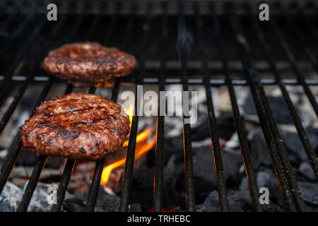 Hausgemachte saftiges Rindfleisch Burger auf dem Grill gegrillt. Feuer von der Holzkohle unter dem Hamburger. Kopieren Sie Platz für Text Stockfoto