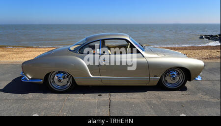 Classic Gold Volkswagen Karmann Ghia an der Strandpromenade geparkt. Stockfoto