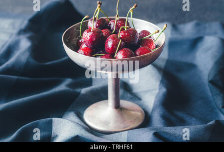 Frische Kirschen in Vintage silver Vase auf dem dunklen Hintergrund Stockfoto
