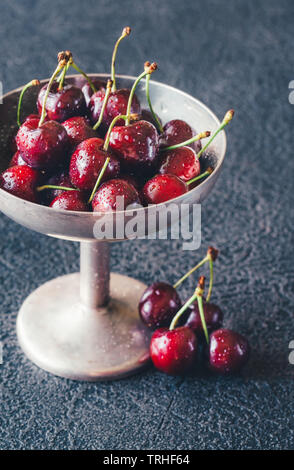 Frische Kirschen in Vintage silver Vase auf dem dunklen Hintergrund Stockfoto