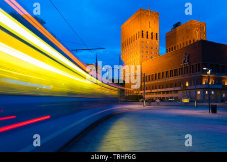 Oslo City Centre, Ansicht bei Nacht einer Straßenbahn in Richtung Rathaus Gebäude (radhus) in Den zentralen Hafen von Oslo, Norwegen. Stockfoto