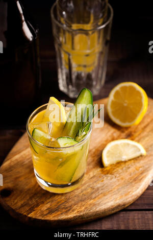 Frische organische Sommer Cocktail mit saurer Ingwer Handwerk Bier oder kombucha Tee mit Gurke und Zitrone auf Holz- Hintergrund. Drink an der Bar Tabelle Stockfoto