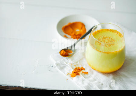 Gesunde ayurvedische Getränke golden Mandelmilch oder Kürbis Kurkuma Latte mit kurkuma Pulver auf weißem Hintergrund close-up Stockfoto