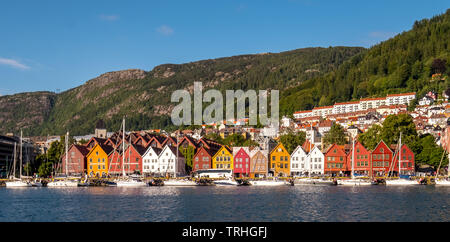 Nordsee, hinter einer bunten Holzhäusern vorne mit angehängten Segelboote im Hafen von Bryggen, dahinter mehr Häuser des Ortes oben Hotel comp Stockfoto