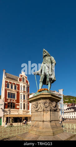 Auf einem steinernen Sockel, die Statue von Ludvig Holberg, Baron von Holberg, mit einem weißen Zaun gerahmt, vor einem strahlend blauen Himmel, um zu sehen, dahinter die Theta Mus Stockfoto