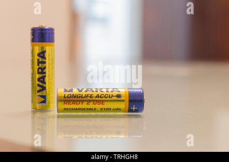 CARRARA, Italien - 06, Juni 2019 - Zwei Varta Akkus auf Glas Tisch. Varta ist ein deutsches Unternehmen, spezialisiert auf die Produktion von batterie Stockfoto