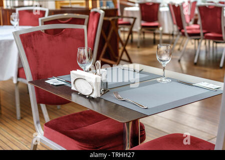 Tische, Stühle und gastronomische Einrichtungen in einem leeren Restaurant. Stockfoto