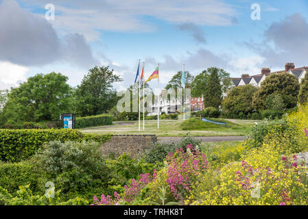 Parade Gärten, einen kleinen öffentlichen Garten in Barry. Im Vordergrund sind bunte Blumen. Über sie hinaus Fahnen wehen für die Partnerstädte. Stockfoto