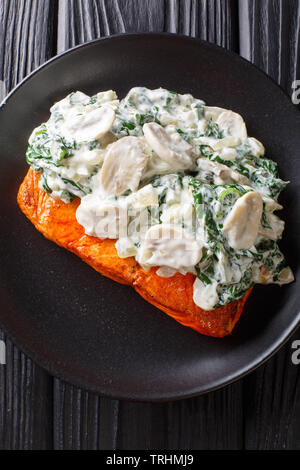 Ganzer Lachs filet gebacken bis zur Perfektion, dann ist es mit Spinat, Champignons, Knoblauch und Sahne in der Nähe auf der Platte auf die Registerkarte Fertig Stockfoto