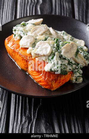 Ganzer Lachs filet gebacken bis zur Perfektion, dann ist es mit Spinat, Champignons, Knoblauch und Sahne in der Nähe auf der Platte auf die Registerkarte Fertig Stockfoto