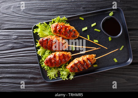 Tsukune japanische Huhn Frikadellen, aufgespießt und in der Regel über Holzkohle gegrillt Close-up auf einem Teller auf den Tisch. horizontal oben Ansicht von oben Stockfoto