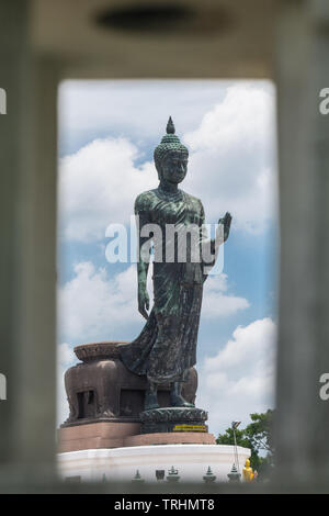 Große Bronzestatue Walking Buddha mit Rahmen von Street Light Thailand Travel Concept. Stockfoto