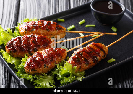 Tsukune japanische Huhn Frikadellen, aufgespießt und in der Regel über Holzkohle gegrillt Close-up auf einem Teller auf den Tisch. Horizontale Stockfoto