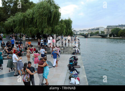 Eine Gruppe von Menschen tanzen Neben der Seine in Paris, Frankreich an einem warmen Sommerabend. Stockfoto